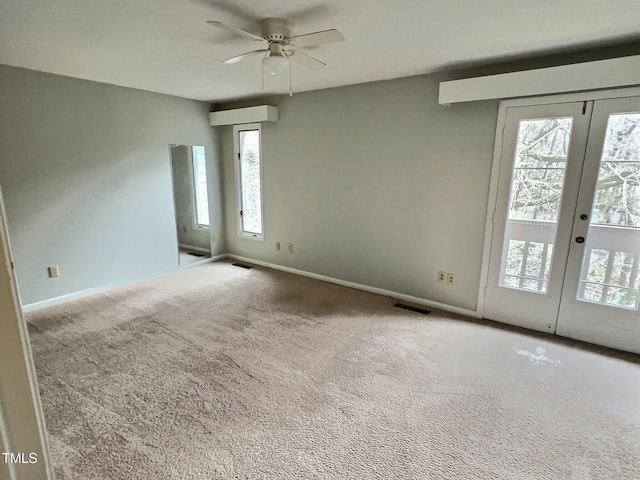 carpeted empty room with french doors and ceiling fan