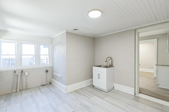 washroom featuring brick wall, crown molding, wooden ceiling, and sink