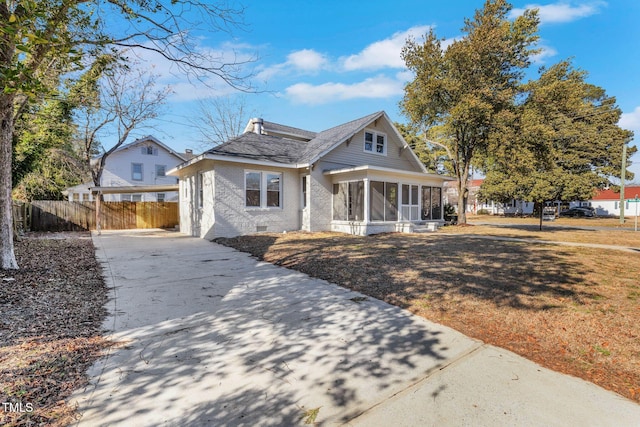 view of front of home with a sunroom and a front lawn