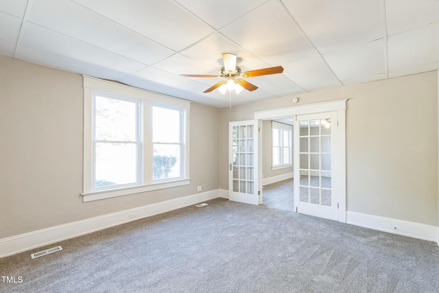 spare room with ceiling fan, a drop ceiling, carpet, and french doors