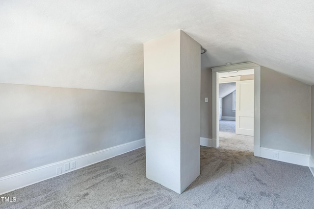 additional living space featuring carpet and vaulted ceiling