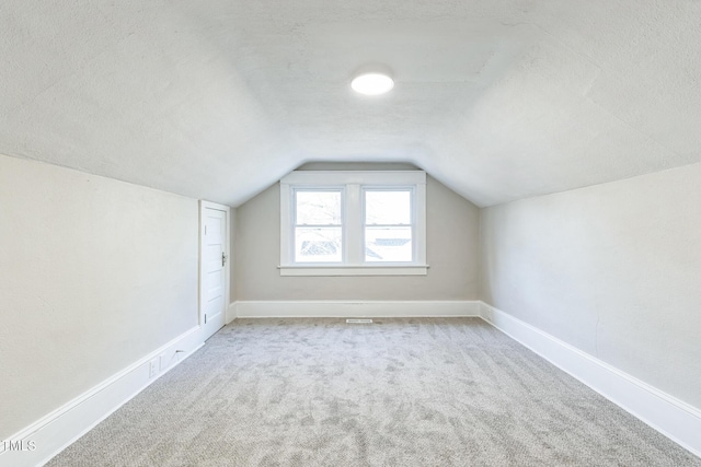 bonus room with carpet, a textured ceiling, and lofted ceiling