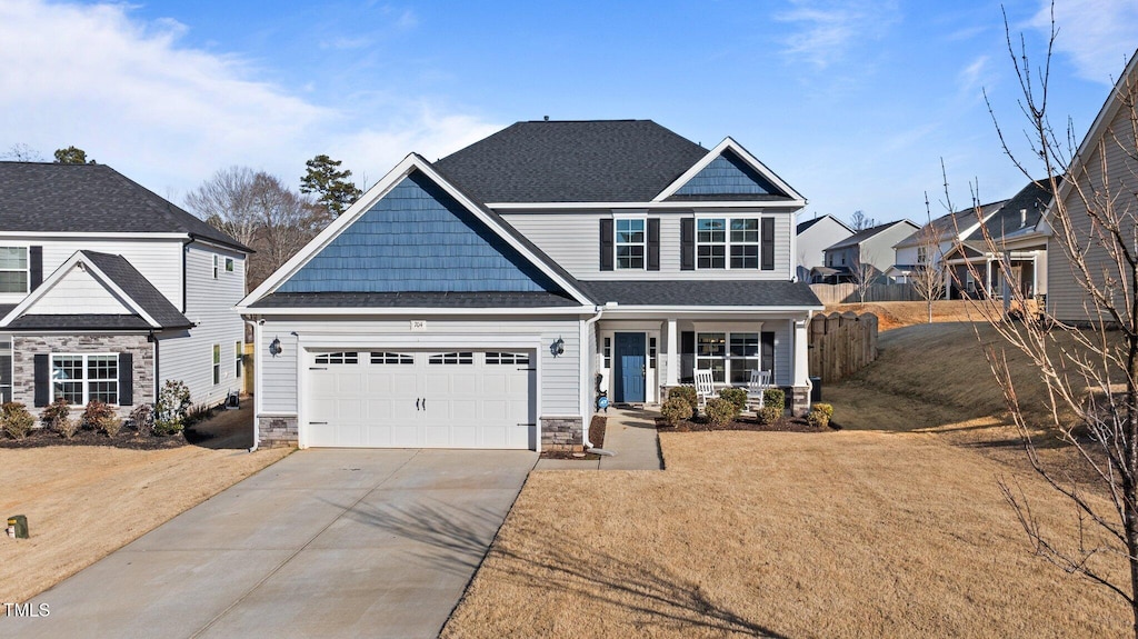 craftsman-style home featuring a garage, a front yard, and covered porch