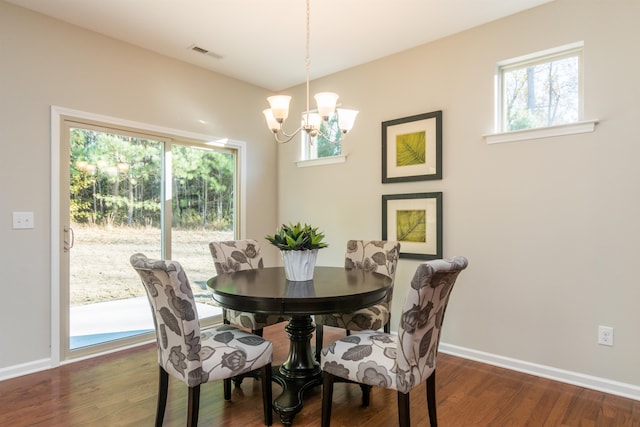 dining area featuring dark hardwood / wood-style floors and an inviting chandelier