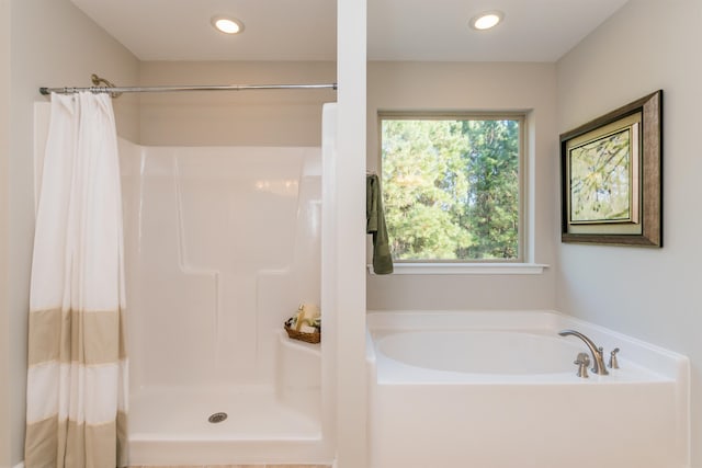 bathroom featuring shower with separate bathtub