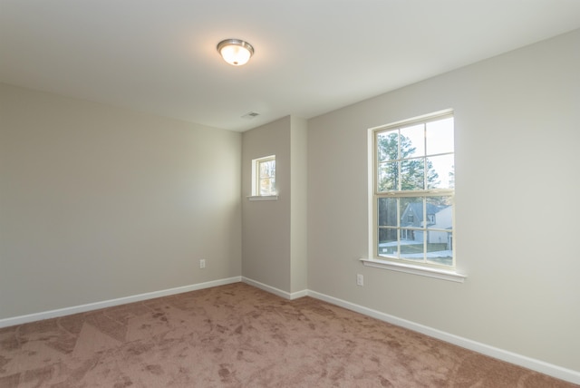 empty room with light colored carpet and a wealth of natural light