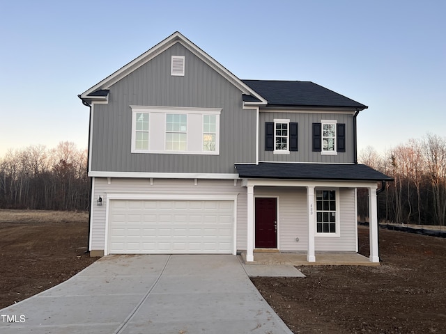 view of property featuring a porch and a garage