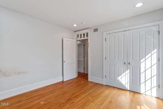 unfurnished bedroom with light hardwood / wood-style floors and a closet