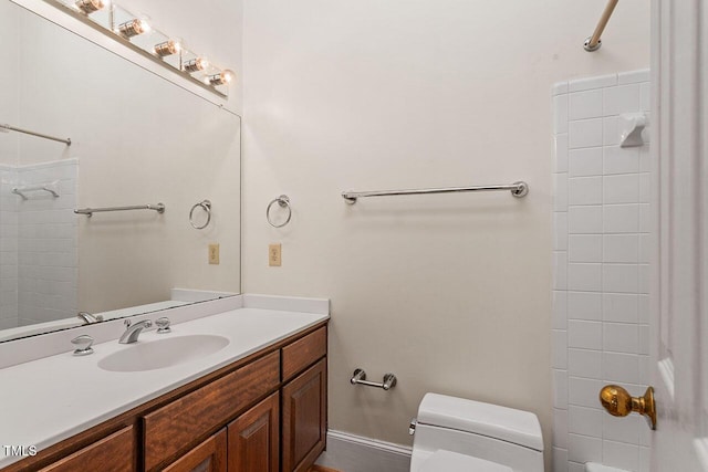 bathroom featuring tiled shower, vanity, and toilet