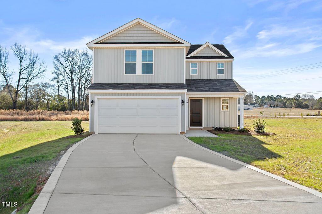 view of front of home with a garage and a front lawn