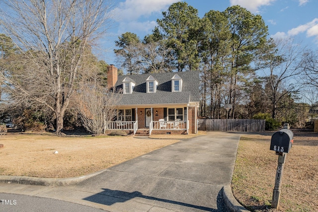 cape cod house with covered porch and a front lawn