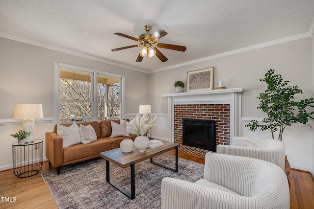 living room with a brick fireplace, a textured ceiling, and hardwood / wood-style flooring