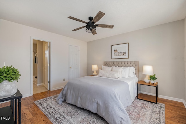 bedroom with ceiling fan, connected bathroom, and hardwood / wood-style flooring