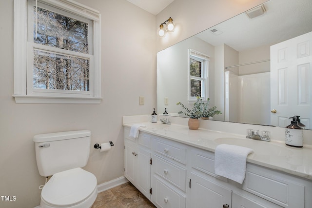 bathroom with a shower, vanity, and toilet