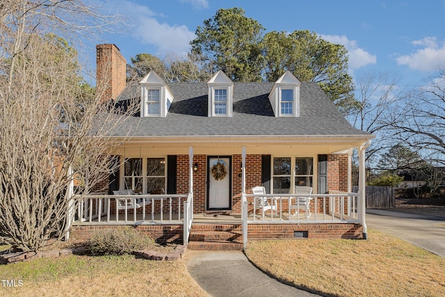 cape cod-style house featuring a porch and a front yard