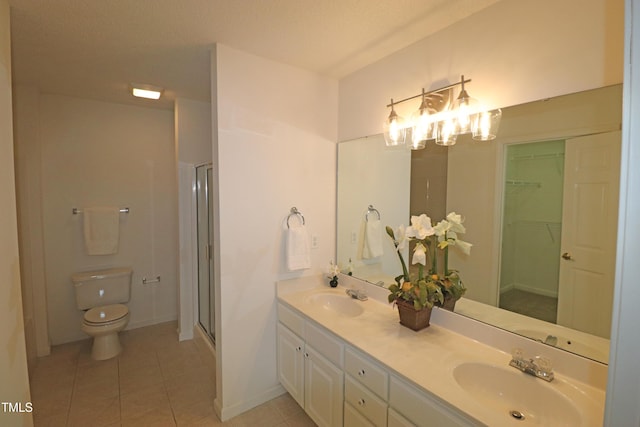 bathroom featuring walk in shower, tile patterned flooring, a textured ceiling, toilet, and vanity