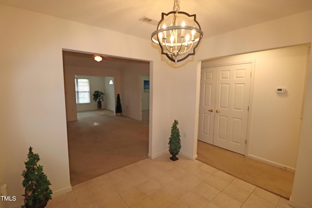 interior space with light colored carpet and an inviting chandelier