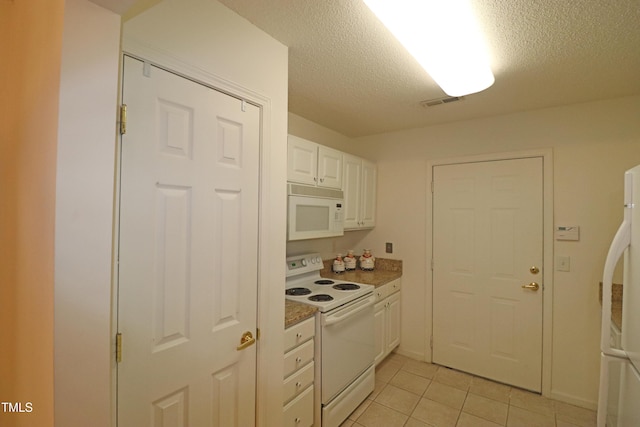 kitchen with white cabinets, light tile patterned floors, white appliances, and a textured ceiling