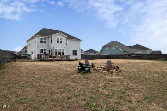 back of house featuring a deck and a lawn