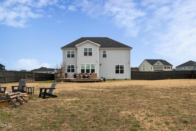 back of property featuring a yard, an outdoor fire pit, and a wooden deck