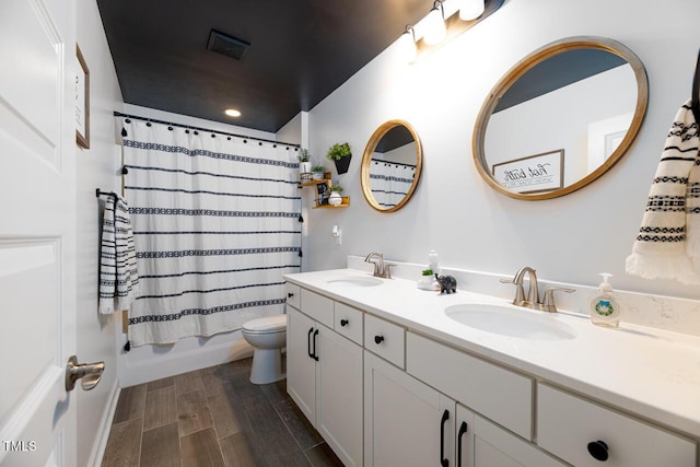 full bathroom with vanity, shower / tub combo, and toilet