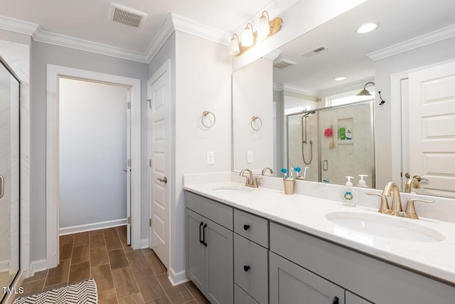 bathroom with vanity, a shower with door, and crown molding