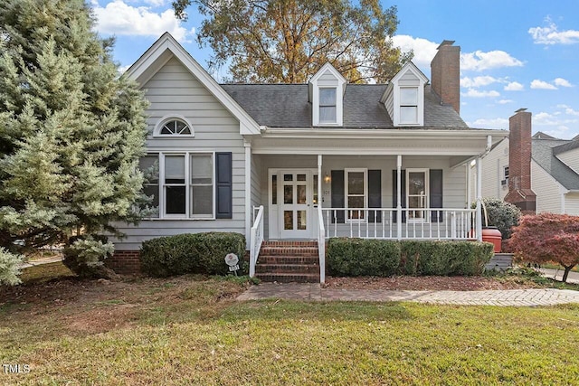 cape cod house with covered porch and a front yard