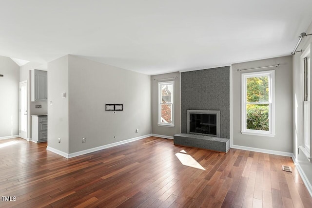 unfurnished living room featuring a fireplace and dark wood-type flooring