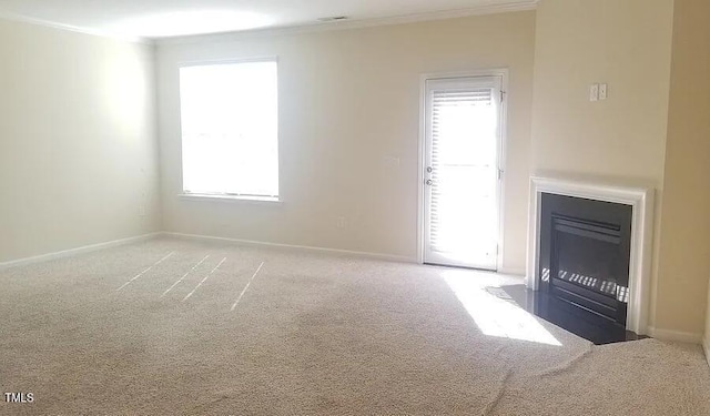 unfurnished living room featuring carpet flooring and ornamental molding