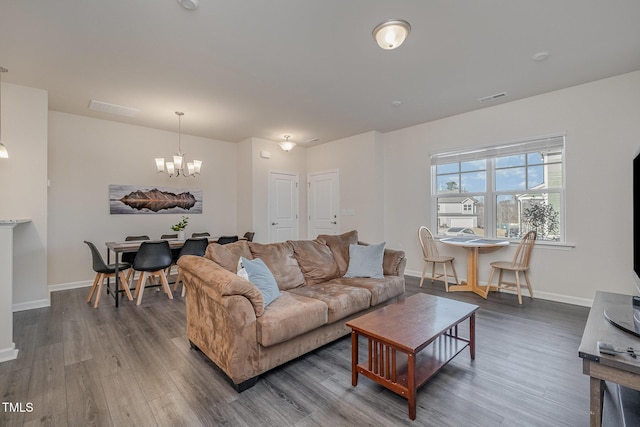 living room with dark hardwood / wood-style flooring and an inviting chandelier