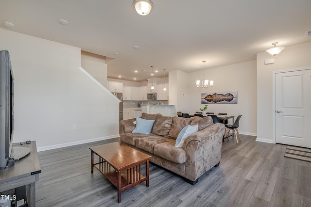 living room with an inviting chandelier and light hardwood / wood-style floors