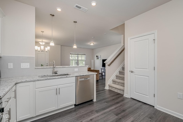 kitchen with pendant lighting, dishwasher, white cabinetry, sink, and light stone counters