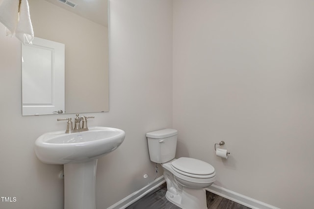 bathroom featuring toilet, sink, and hardwood / wood-style floors