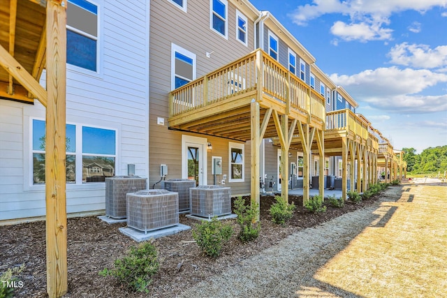 back of house with central AC and a wooden deck