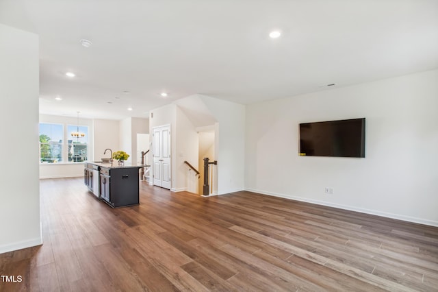 unfurnished living room with hardwood / wood-style floors and sink