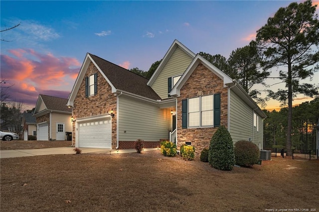 view of front of home with driveway, stone siding, fence, an attached garage, and central AC unit