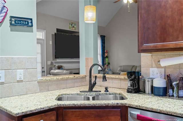 kitchen featuring a sink, ceiling fan, light stone counters, decorative backsplash, and stainless steel dishwasher