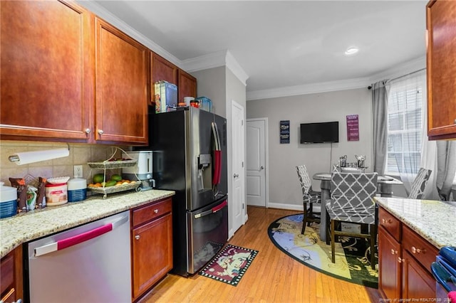 kitchen featuring light stone countertops, ornamental molding, appliances with stainless steel finishes, light wood-type flooring, and backsplash