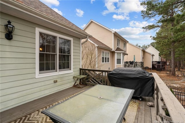 wooden deck with outdoor dining area and a grill