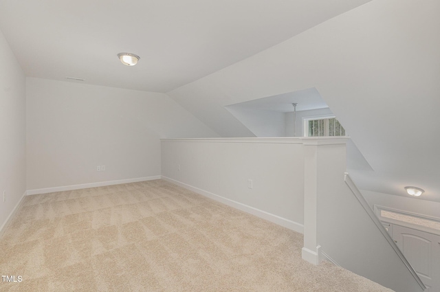 additional living space featuring light carpet and lofted ceiling