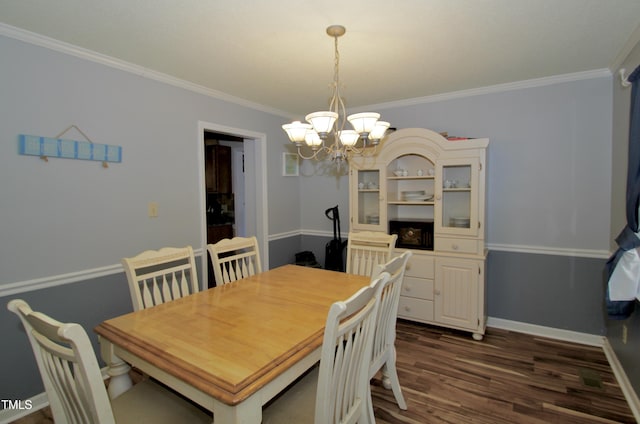 dining room with dark hardwood / wood-style floors, an inviting chandelier, and ornamental molding