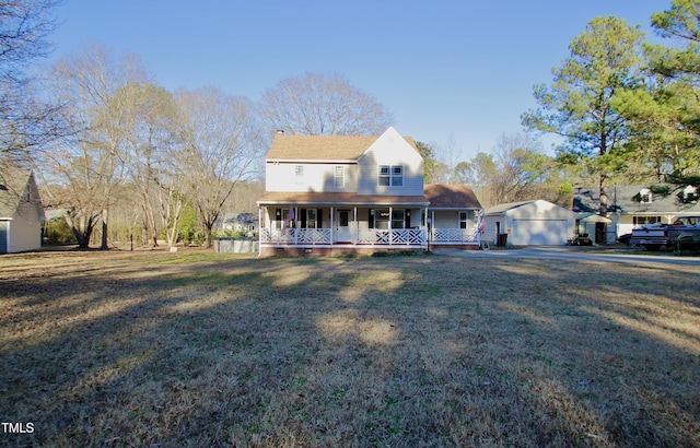 farmhouse with an outbuilding, a garage, a porch, and a front yard