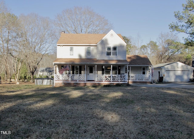 farmhouse-style home with covered porch, a front lawn, an outbuilding, and a garage