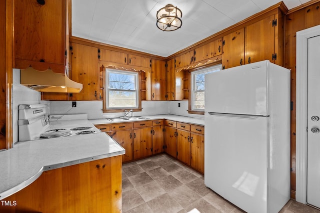 kitchen featuring sink, white refrigerator, kitchen peninsula, decorative backsplash, and range