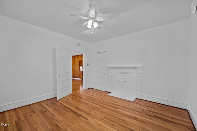 empty room with ceiling fan and light hardwood / wood-style flooring