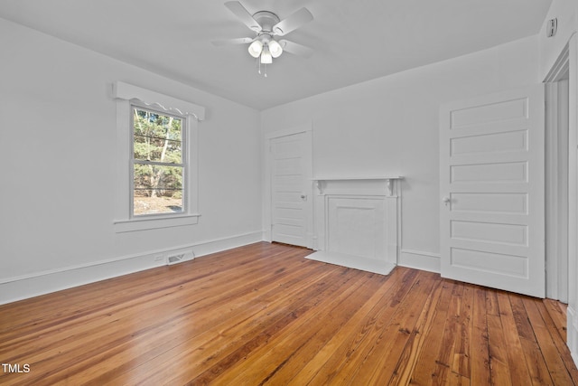 unfurnished living room with ceiling fan and hardwood / wood-style floors