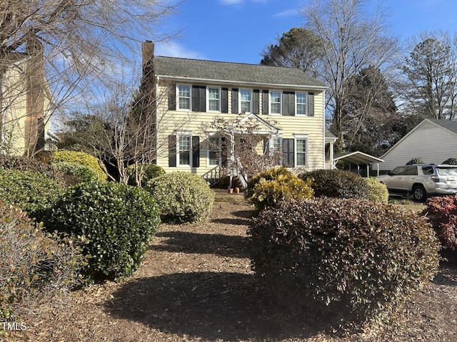 colonial house featuring a carport