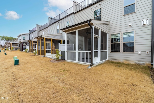 rear view of property with central AC, a sunroom, and a yard