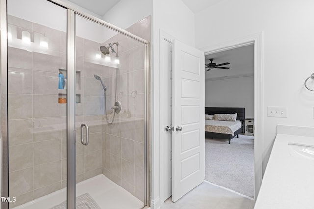 bathroom featuring ceiling fan, a shower with shower door, and sink