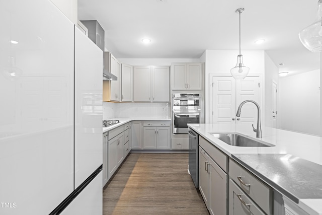 kitchen featuring backsplash, sink, gray cabinets, decorative light fixtures, and stainless steel appliances